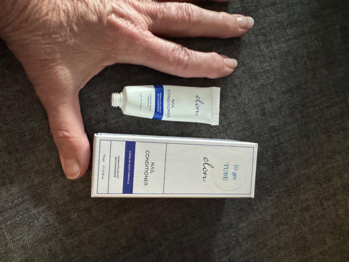 A customer's hand beside the 10-gram Elon Nail Conditioner tube and box